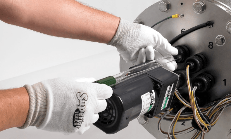 A pair of hands inspecting a lamp that is part of the TrojanUVFit AOP system.